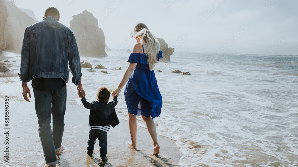 Happy family walkin together at the beach