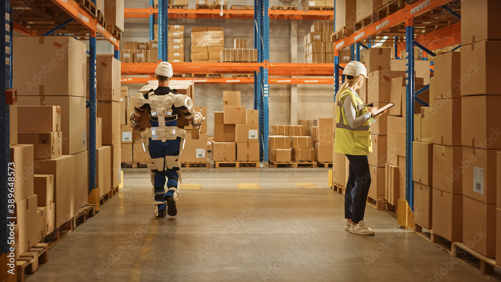 High-Tech Futuristic Warehouse: Manager Scans Packages for Inventory, Delivery in the Background Wor