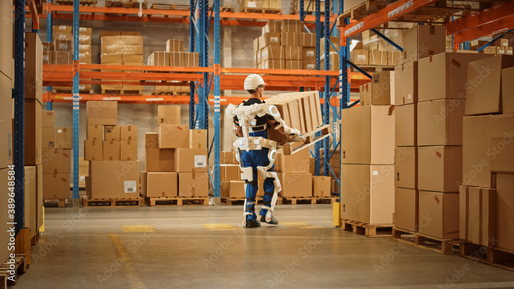 High-Tech Futuristic Warehouse: Worker Wearing Advanced Full Body Powered exoskeleton, Walks with He