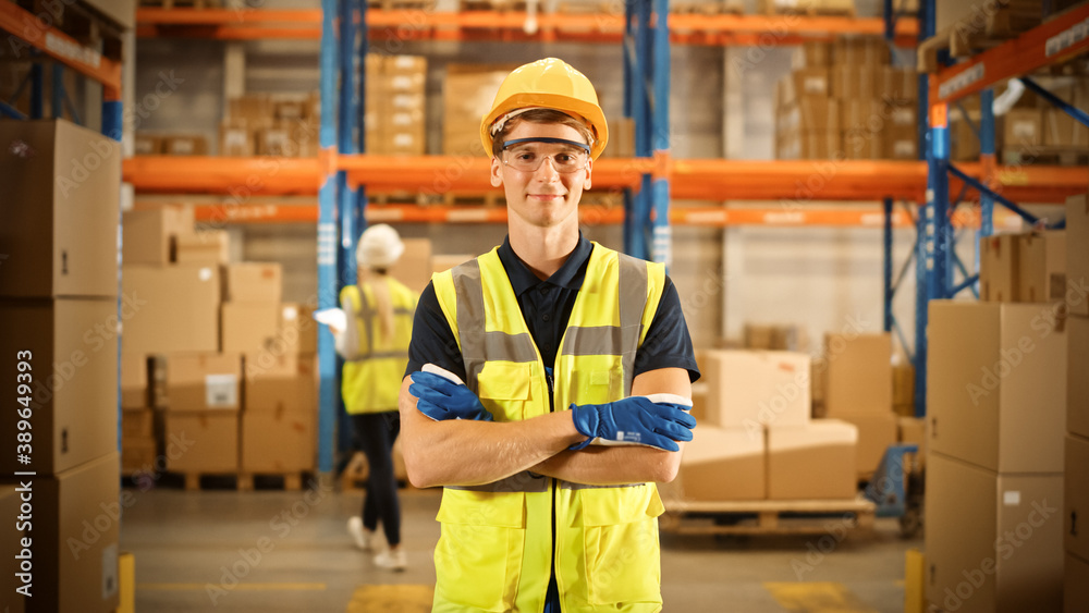 Handsome Smiling Worker Wearing Hard Hat, Standing with Crossed Arms in the Retail Warehouse full of