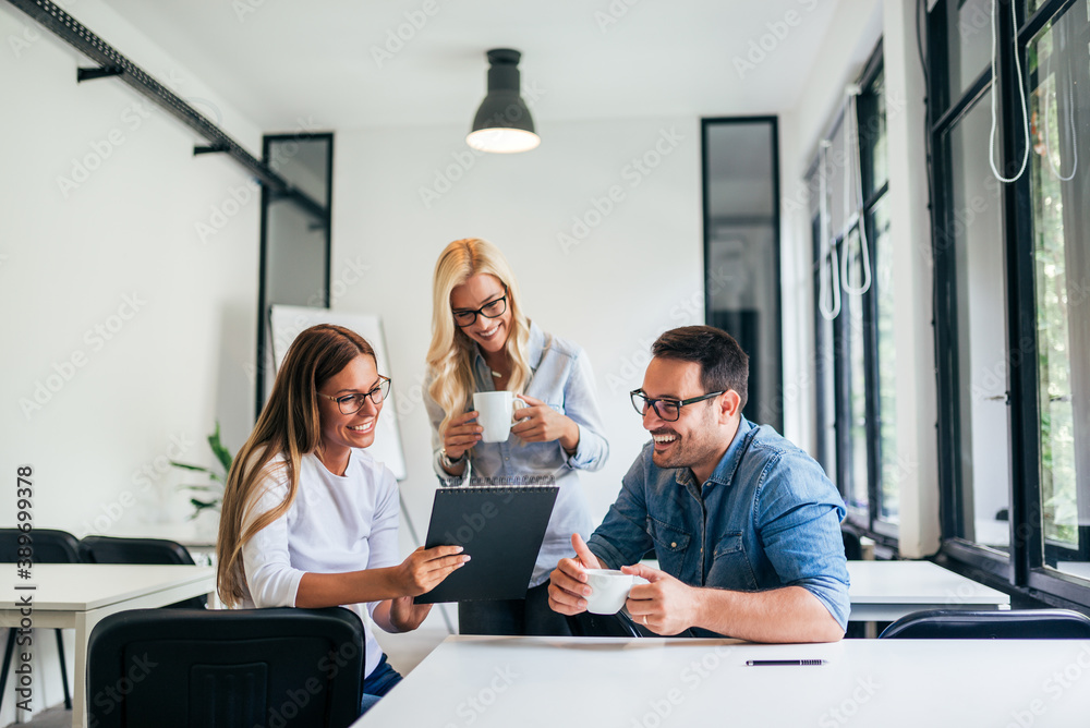 Smiling coworkers discussing in a modern coworking office.