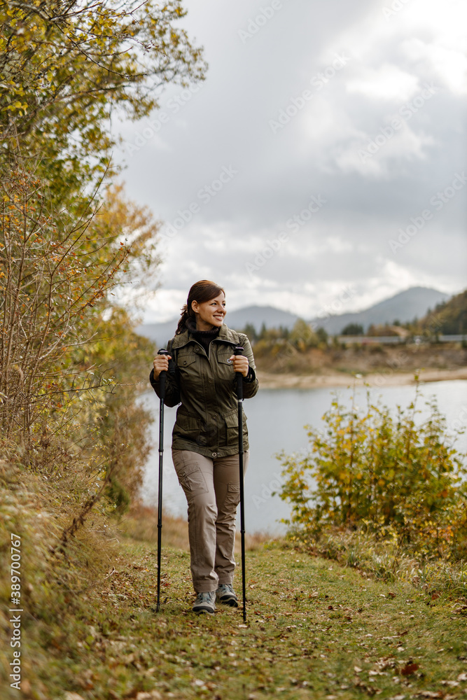 Dressed in a hiking outfit, nature in the background.