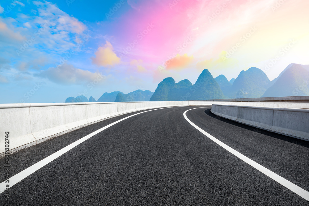 Country asphalt road and green mountain natural scenery in Guilin at sunrise,China.