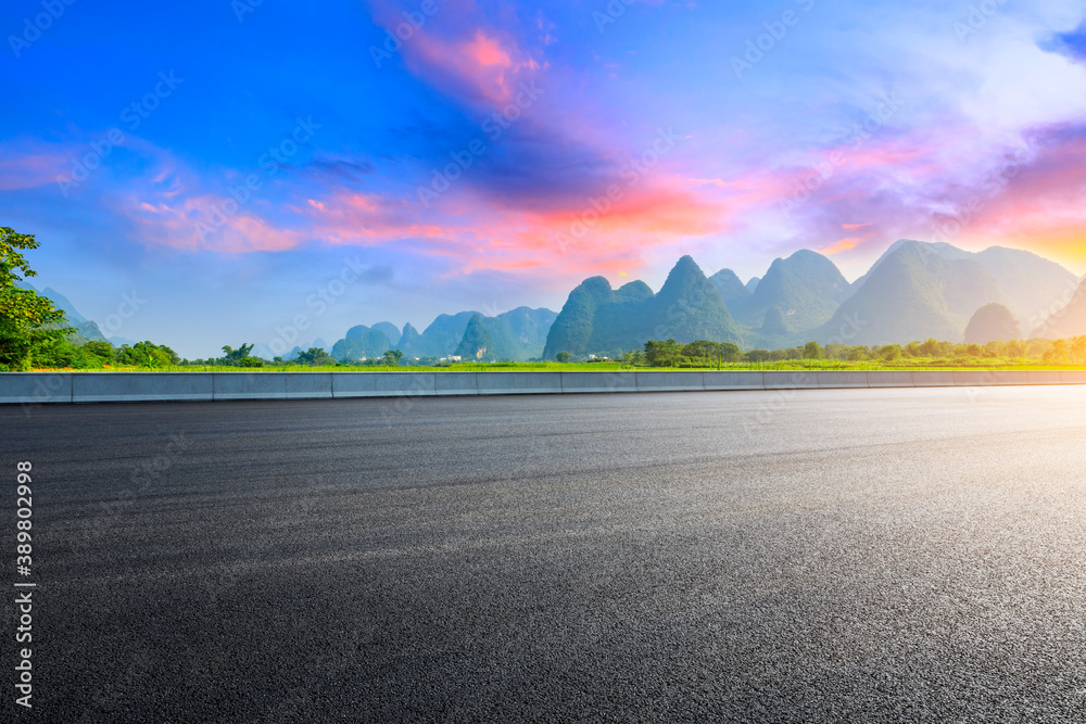 Country asphalt road and green mountain natural scenery in Guilin at sunrise,China.