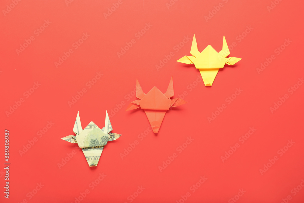 Origami bulls as symbol of year 2021 on color background