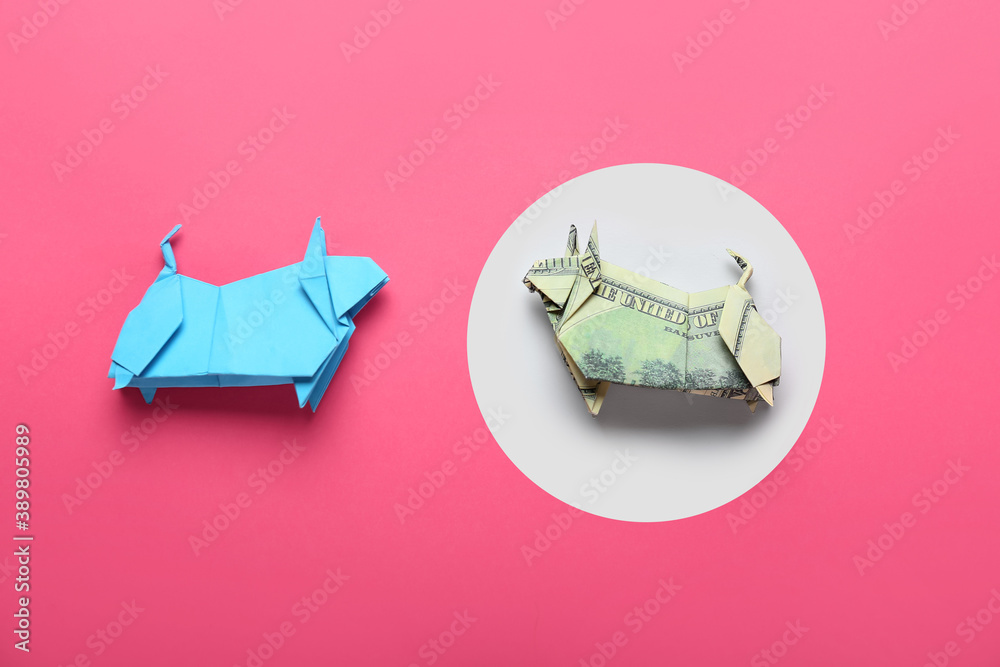 Origami bulls as symbol of year 2021 on color background