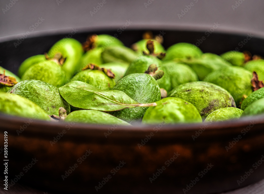 A feijoa fruits (yet known as acca sellowiana) on a dark gray background.
