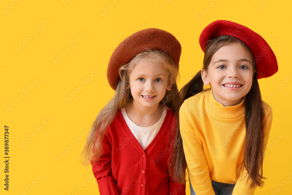 Cute little children in autumn clothes on color background