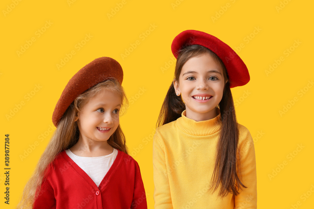 Cute little children in autumn clothes on color background