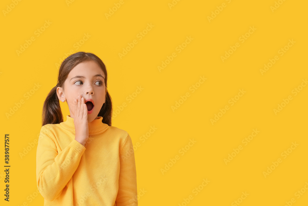 Surprised little girl in autumn clothes on color background