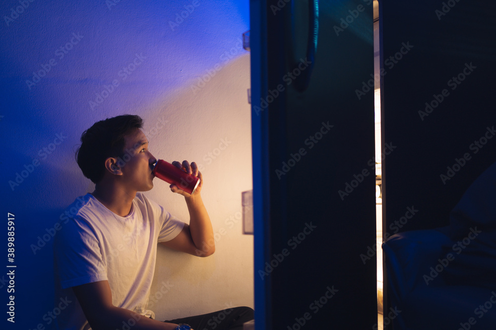  Asian men he is opening the refrigerator.Drink soft drinks at night