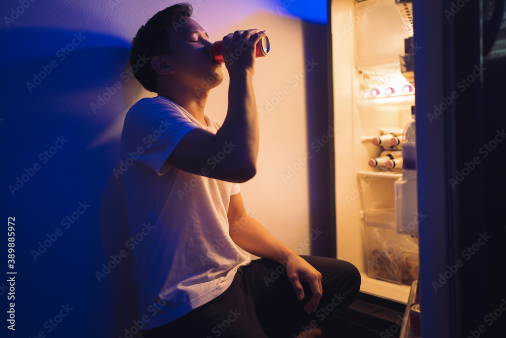  Asian men he is opening the refrigerator.Drink soft drinks at night