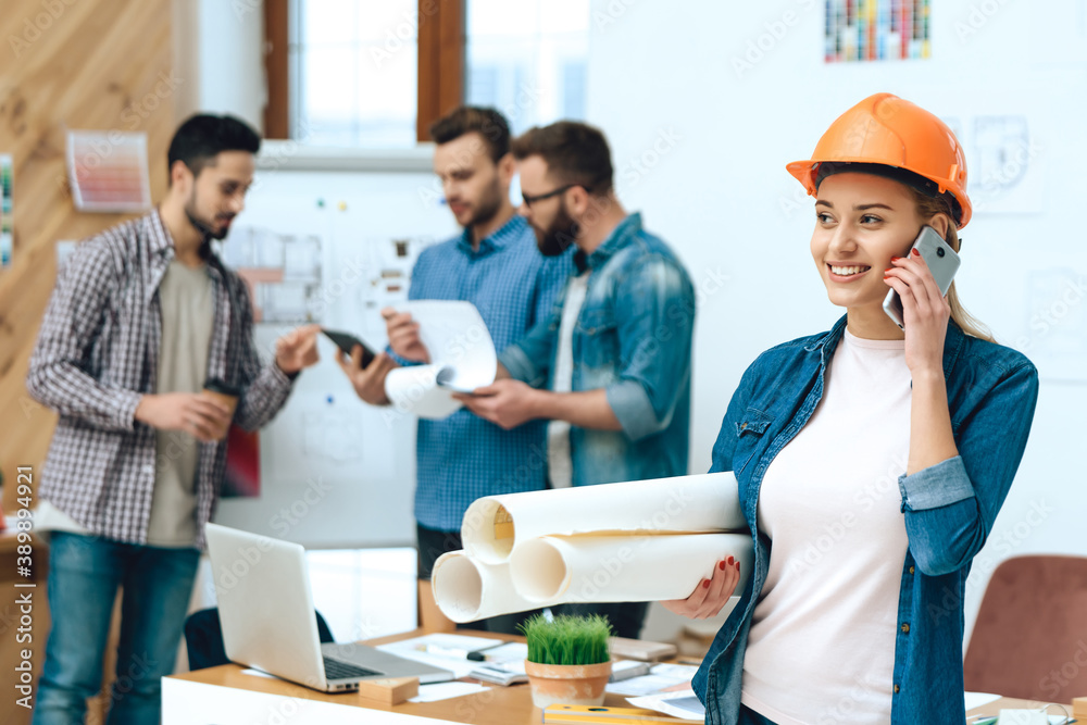 The girl in the helmet speaks on phone and smiles.