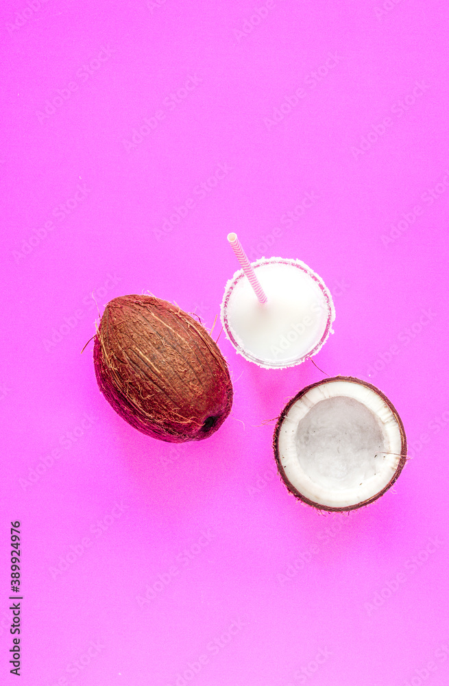 cocktail with coconut on purple background top view