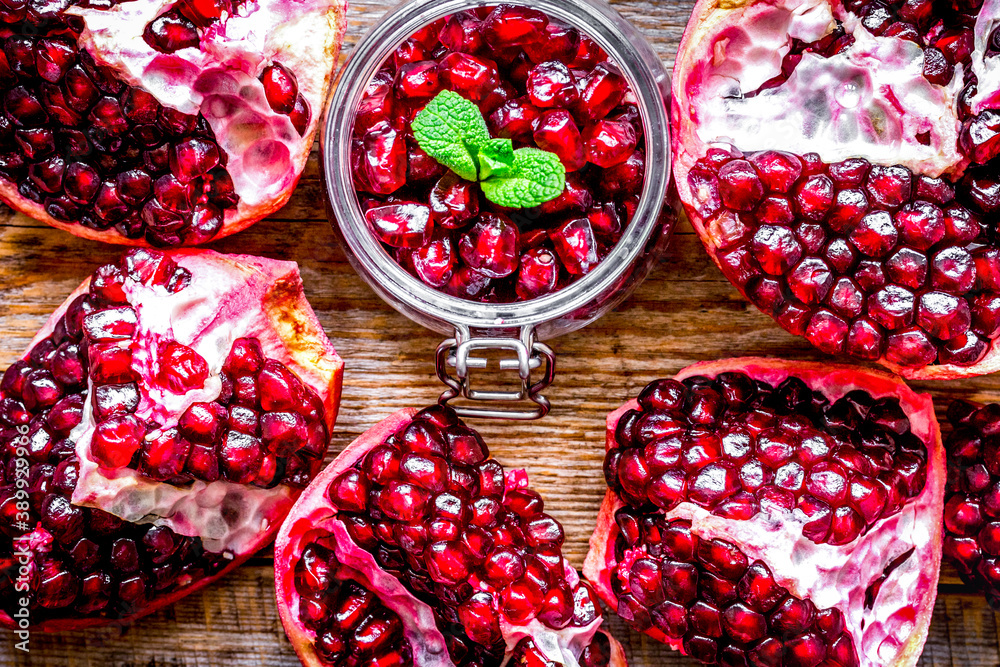 sliced pomegranate on wooden background top view