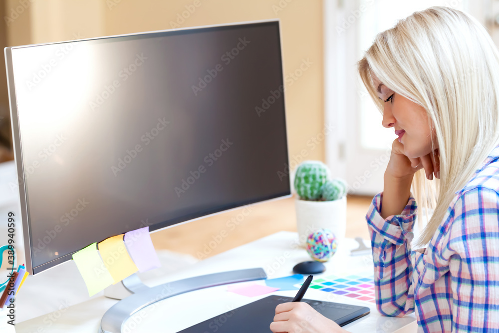 Graphic designer using her graphic tablet in a home office