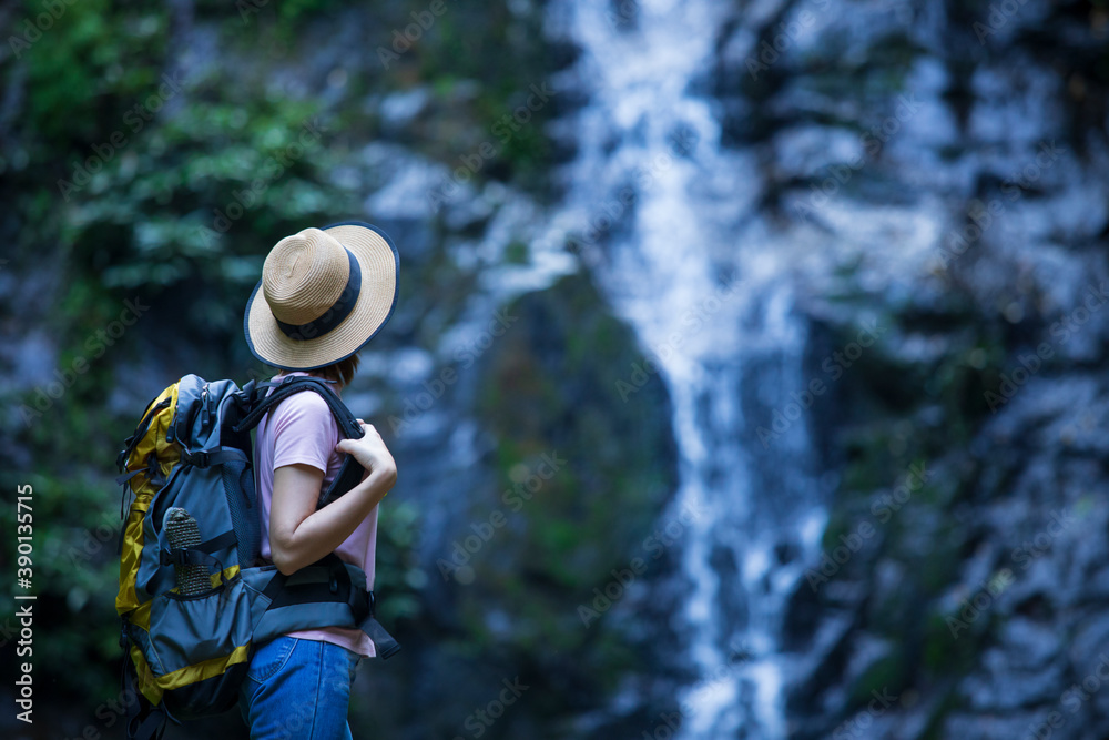 Women with backpackers enjoy waterfalls, women in nature, backpackers, nature tourism concept.