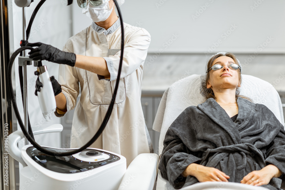 Young woman preparing for a rejuvenation treatment at medical SPA office with a doctor on the backgr