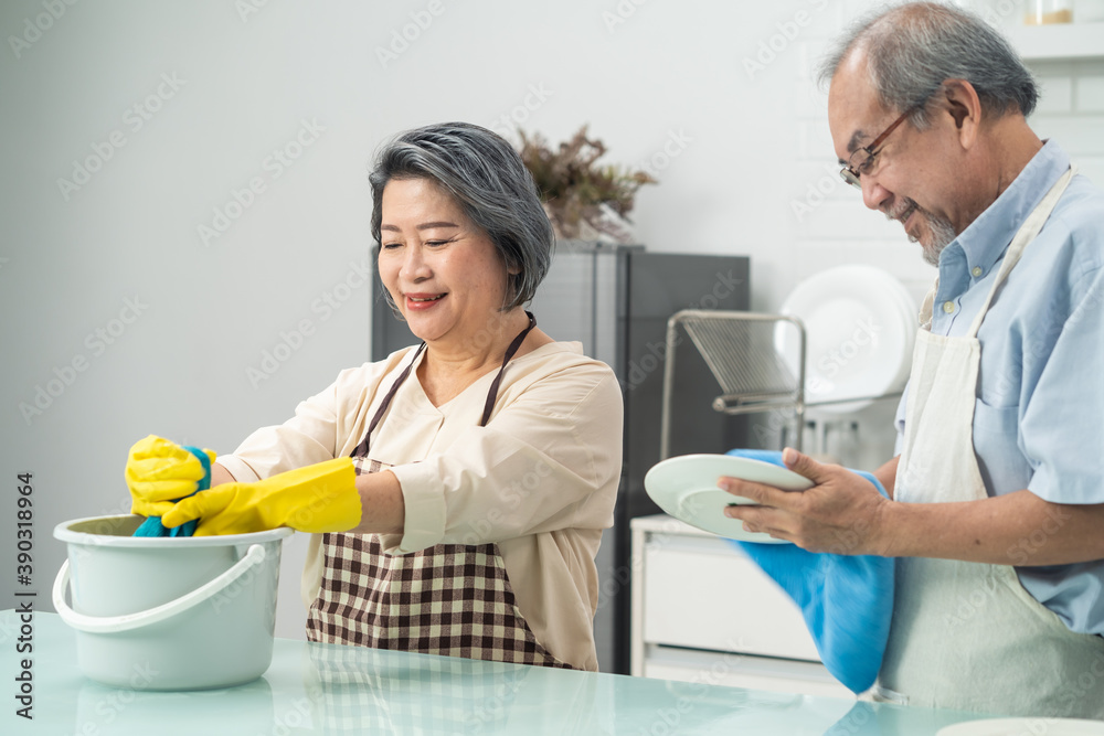 亚洲一对老年夫妇在厨房里互相帮助做家务。