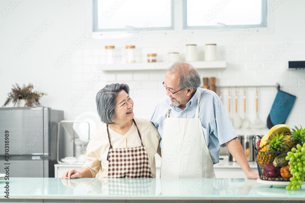 亚洲祖父母夫妇在厨房里互相微笑