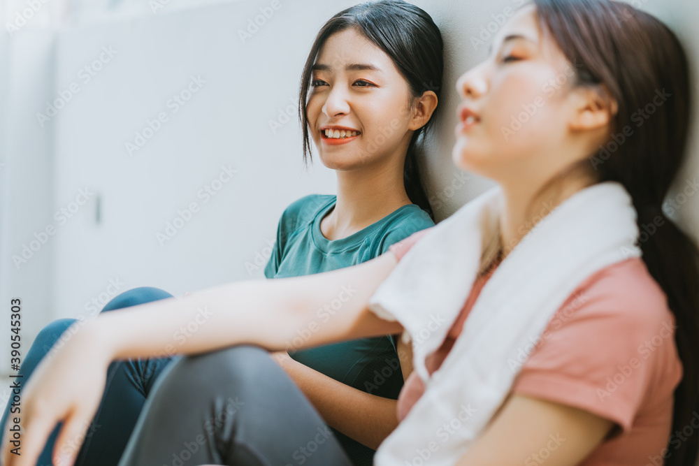 两名亚洲女性在瑜伽课上休息