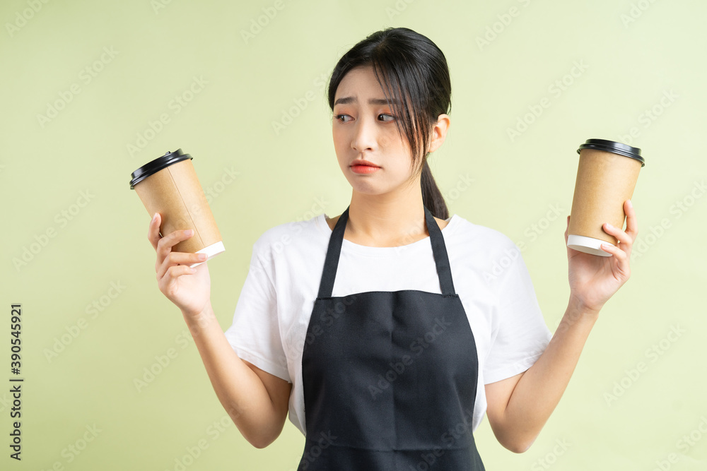 拿着两杯咖啡的亚洲女服务员