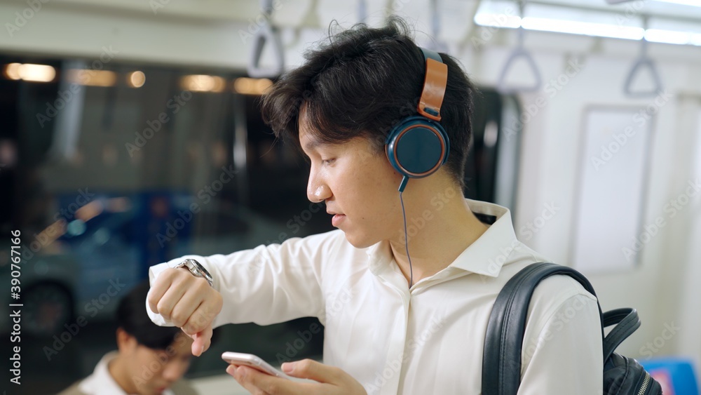 Businessman using mobile phone on public train . Urban city lifestyle commuting concept .