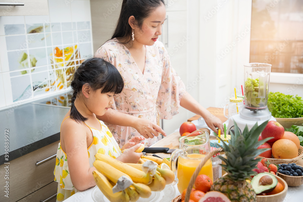 快乐的亚洲家庭母亲和她的女儿喜欢准备新鲜的水果和蔬菜