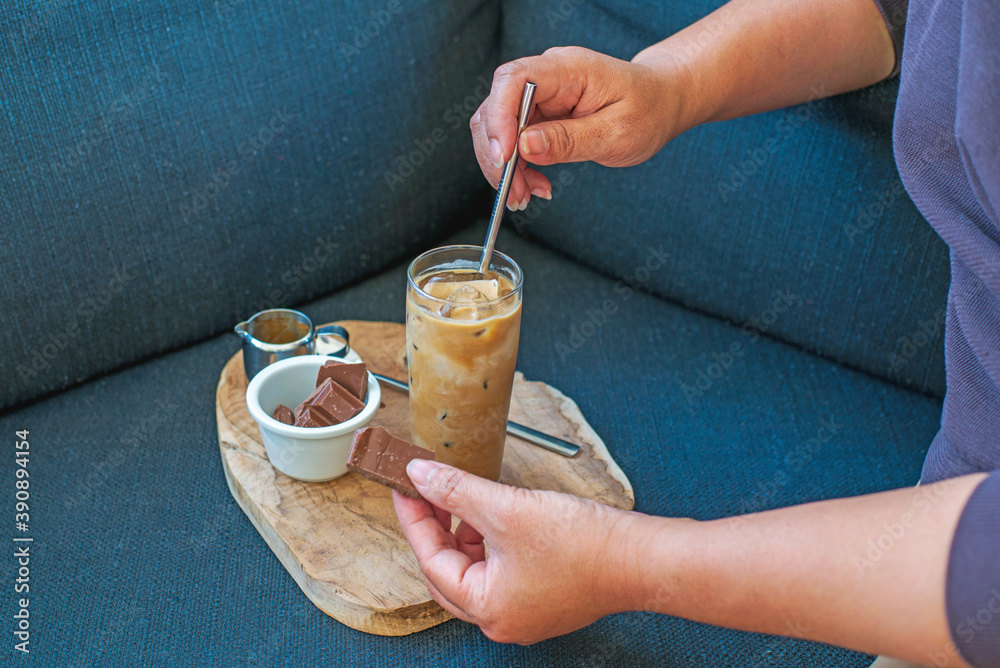 A woman drinking iced coffee at home, afternoon coffee break after work