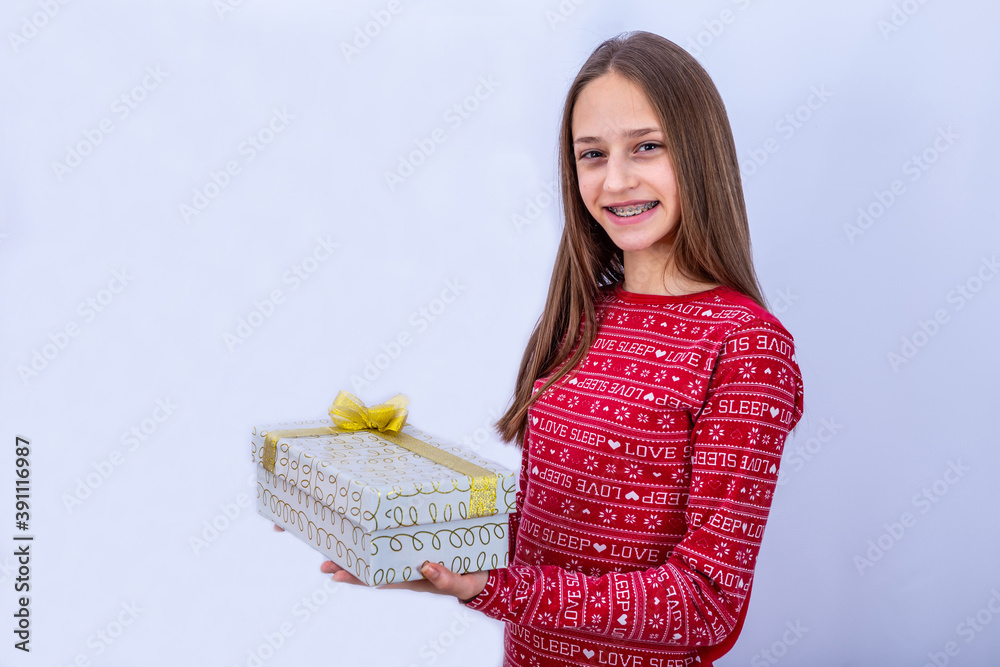 Young caucasian girl with dental braces is smiling. Emotional girl holding gifts and showing happine