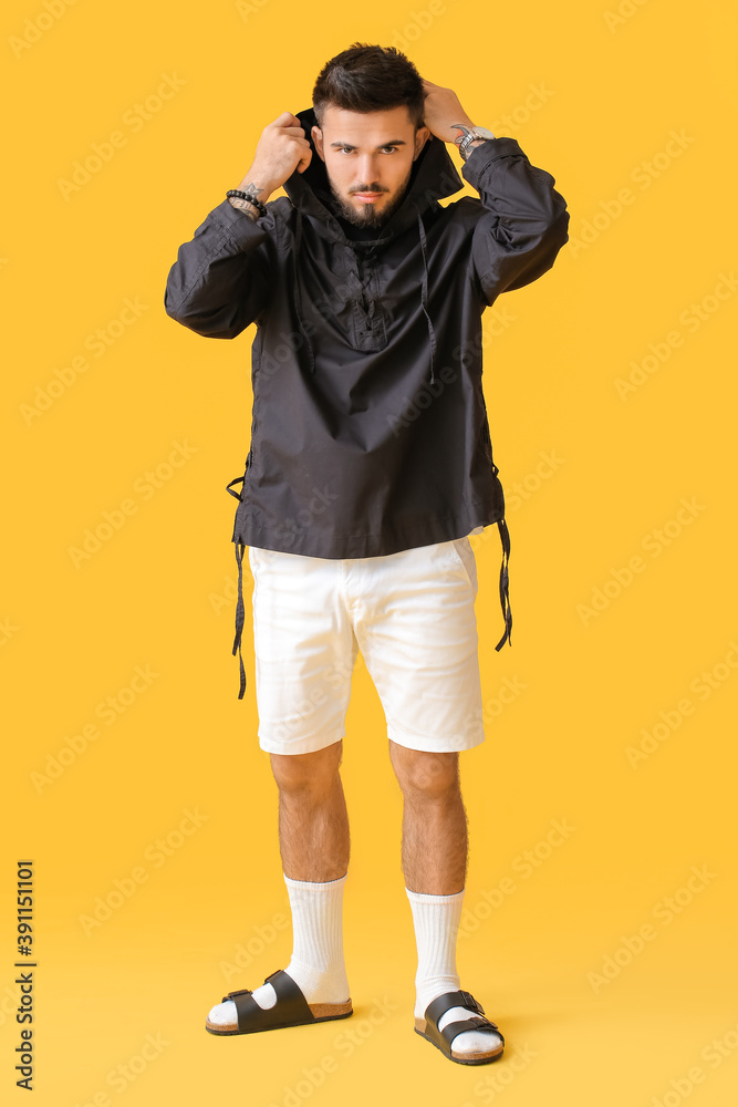 Fashionable young man on color background