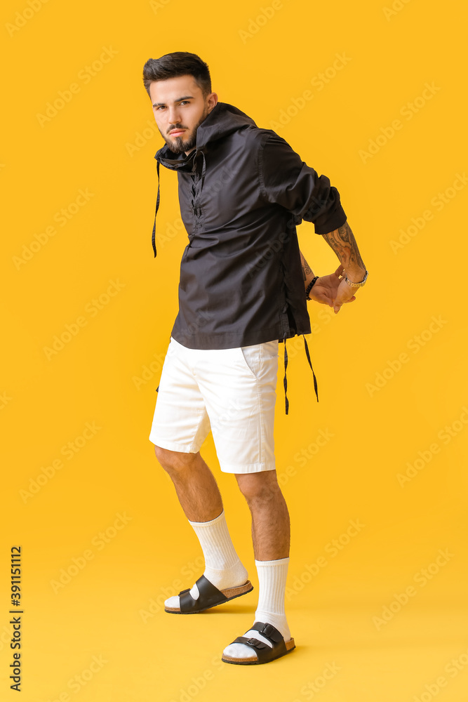 Fashionable young man on color background