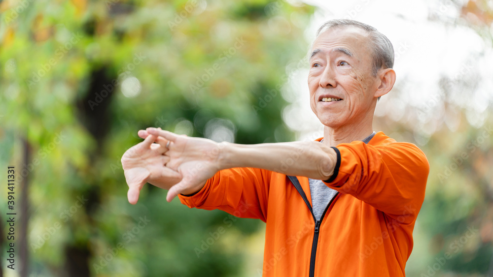 公園でストレッチをするシニア男性