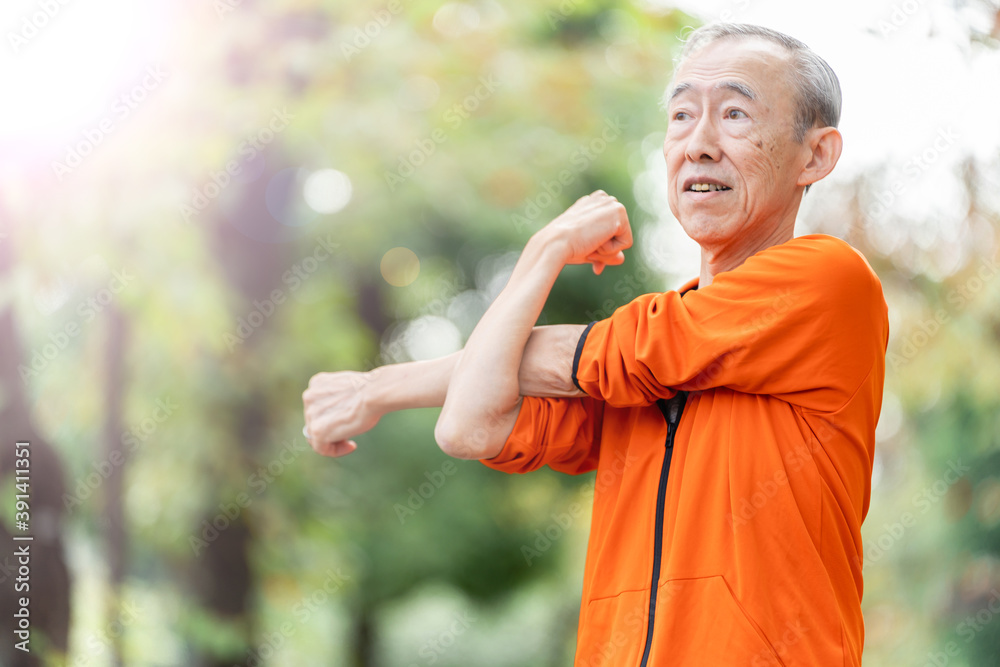 公園でストレッチをするシニア男性