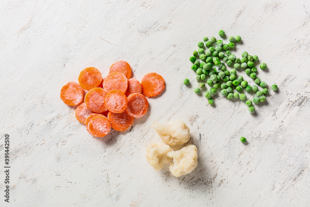 Different frozen vegetables on white background