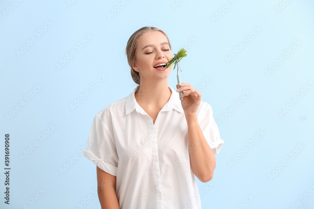 年轻女子在彩色背景下吃麦草