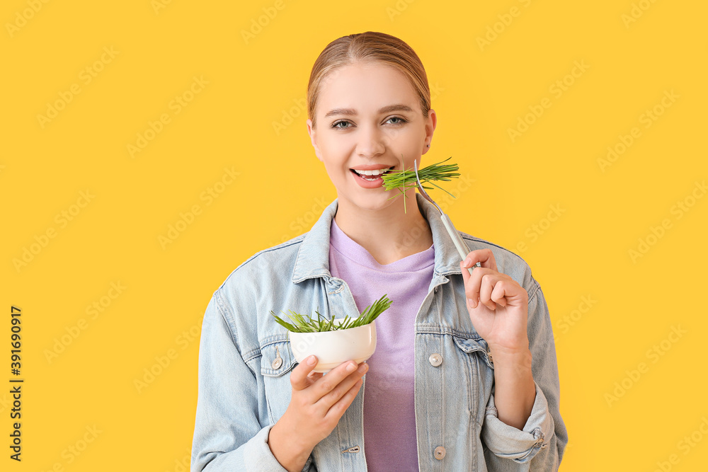 年轻女子在彩色背景下吃麦草