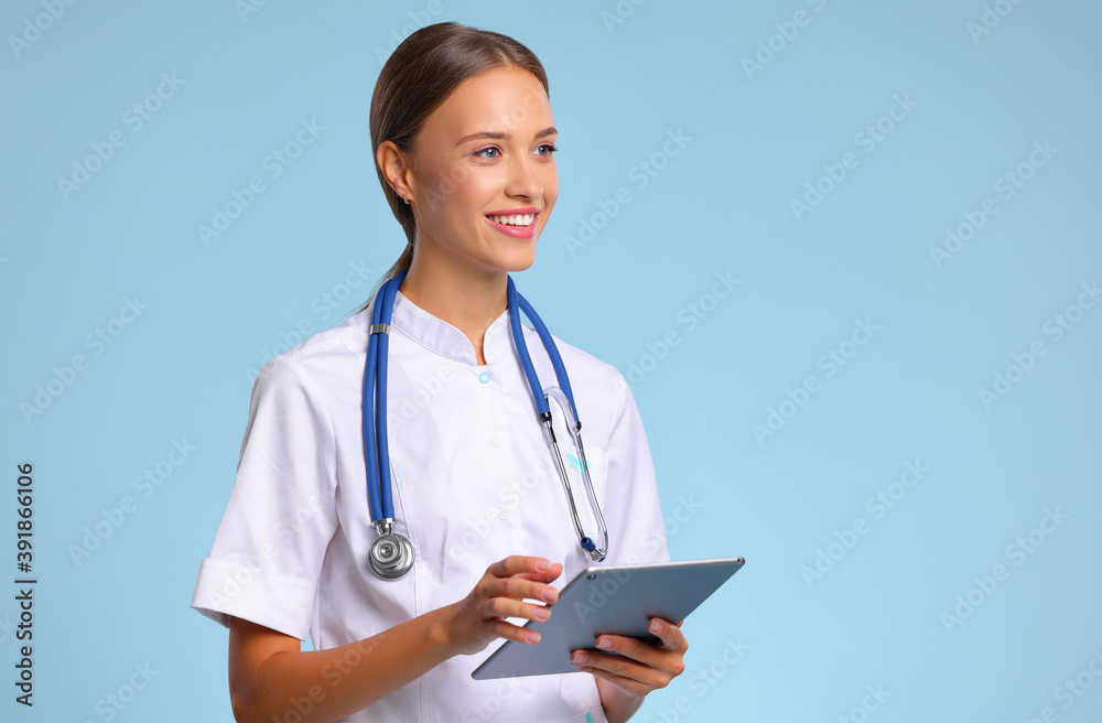 friendly doctor nurse with tablet wireless computer smiles in isolated against   blue background