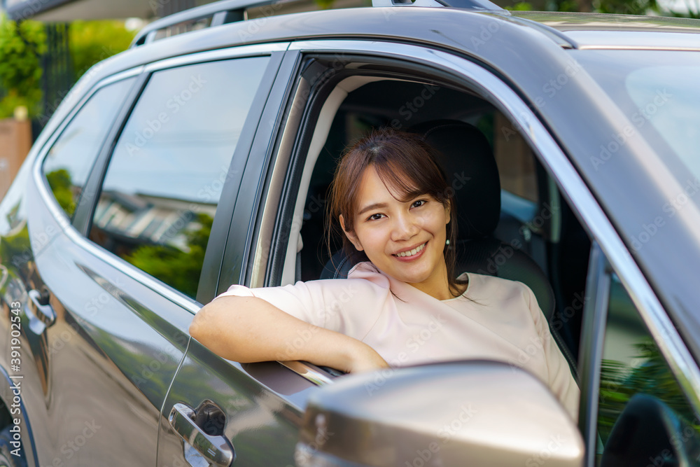 亚洲快乐的年轻美女微笑着驾驶汽车，准备和她一起旅行