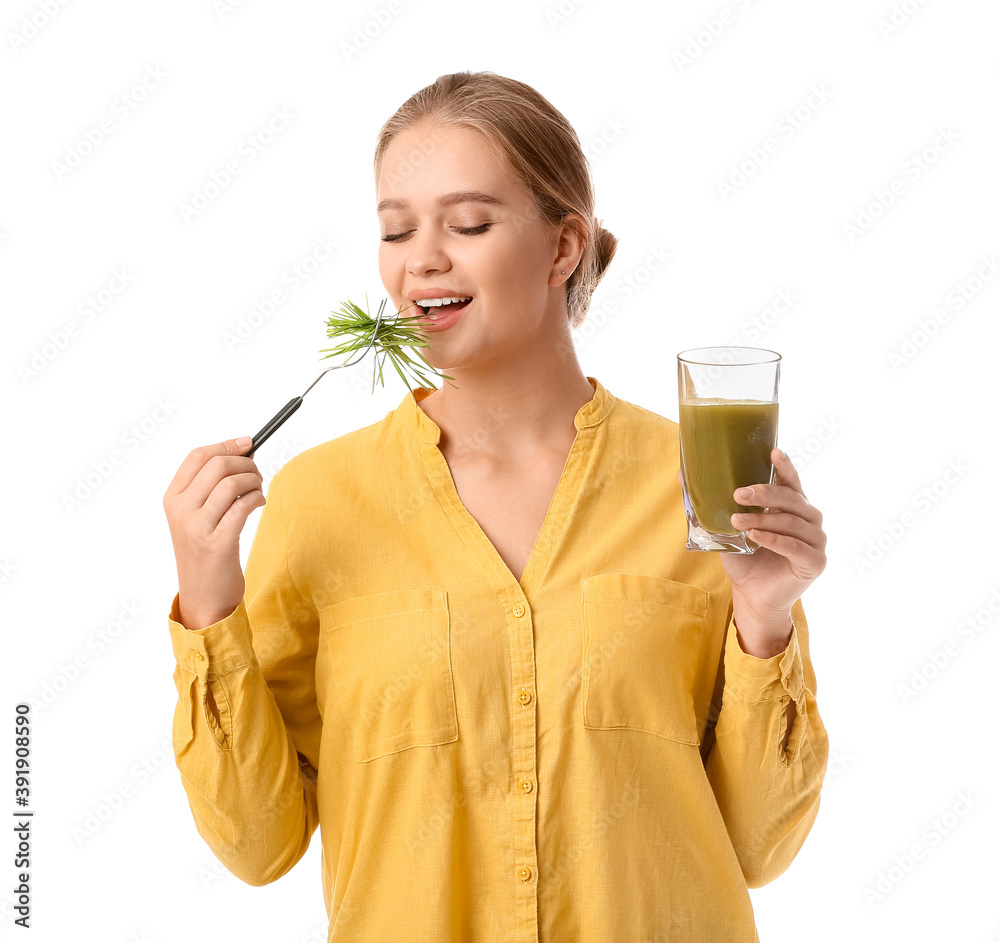 Young woman with wheatgrass and juice on white background