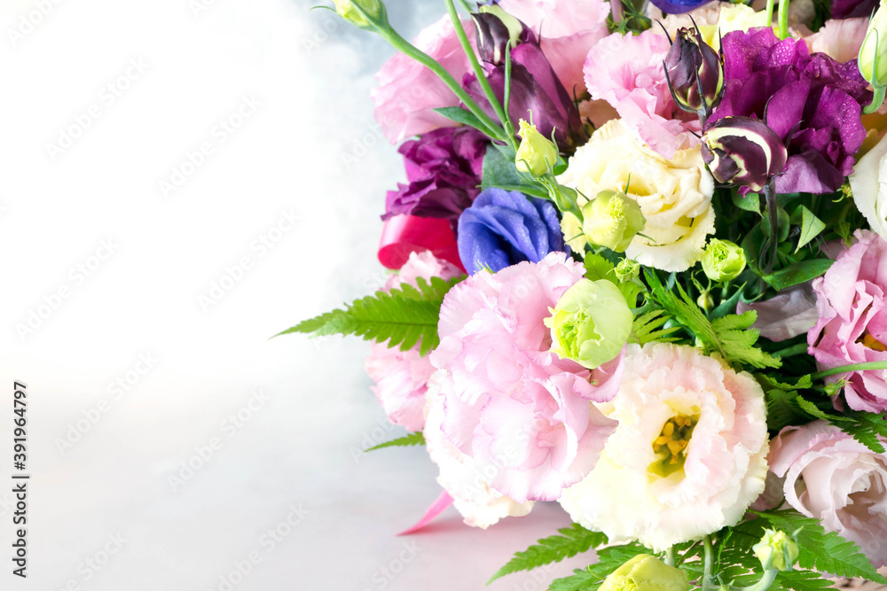 Summer wedding bouquet of multicolored roses close-up on gray and white background. Pink, yellow, li