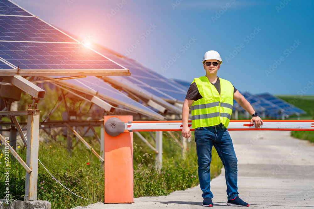 Engineer in worker helmet on solar panels background. Solar power panel. Green energy. Electricity. 