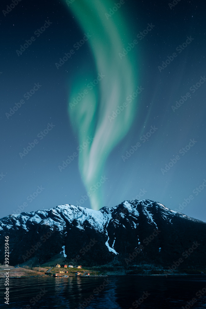 Aurora borealis and mountain landscape with small norwegian village