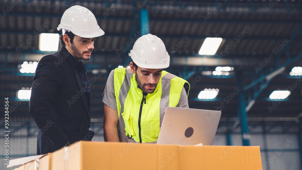 Two factory workers working and discussing manufacturing plan in the factory . Industry and engineer