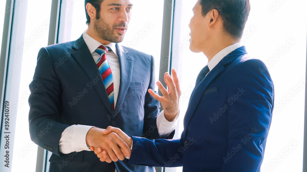 Business people handshake in corporate office showing professional agreement on a financial deal con