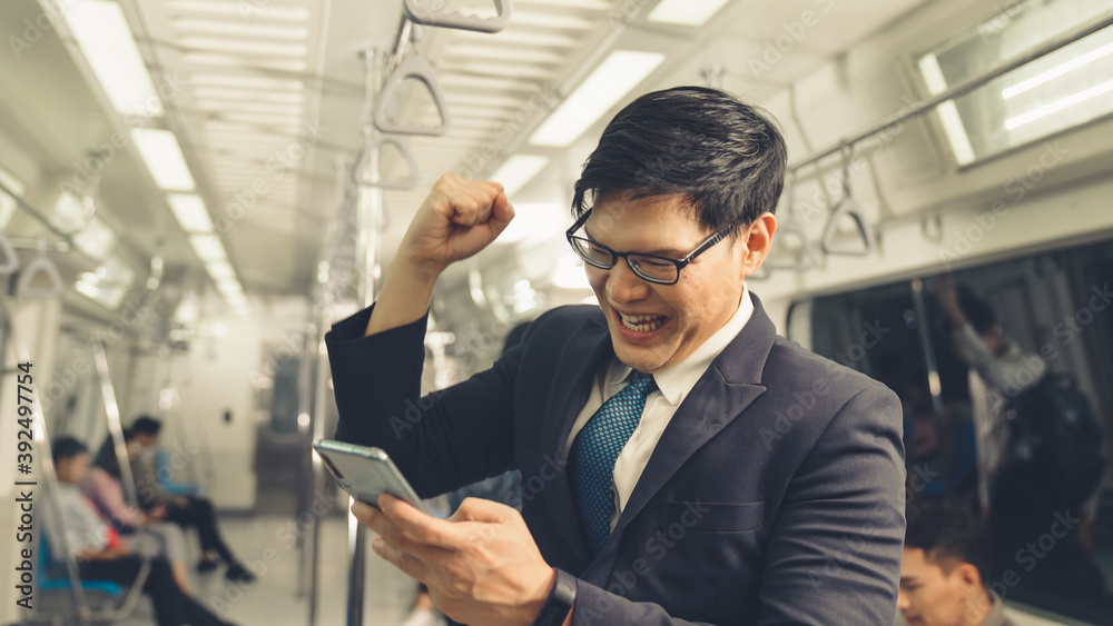 Businessman using mobile phone on public train . Urban city lifestyle commuting concept .