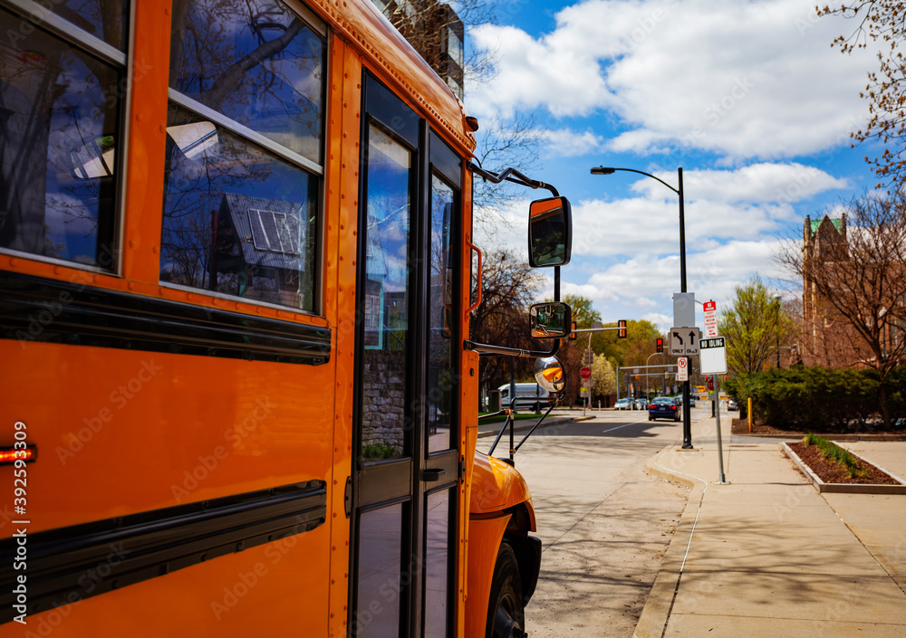 Orange school bus on USA city street view of the front door