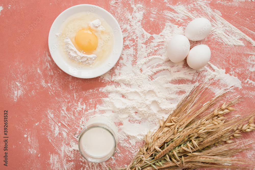 Baking background. Food ingredients for baking flour, eggs, sugar on pink background flat lay. Bakin