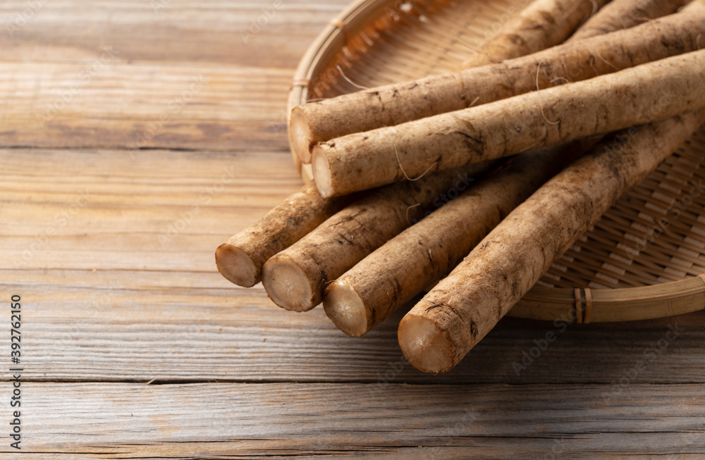 Burdock in a bamboo colander placed in the background of a wooden board