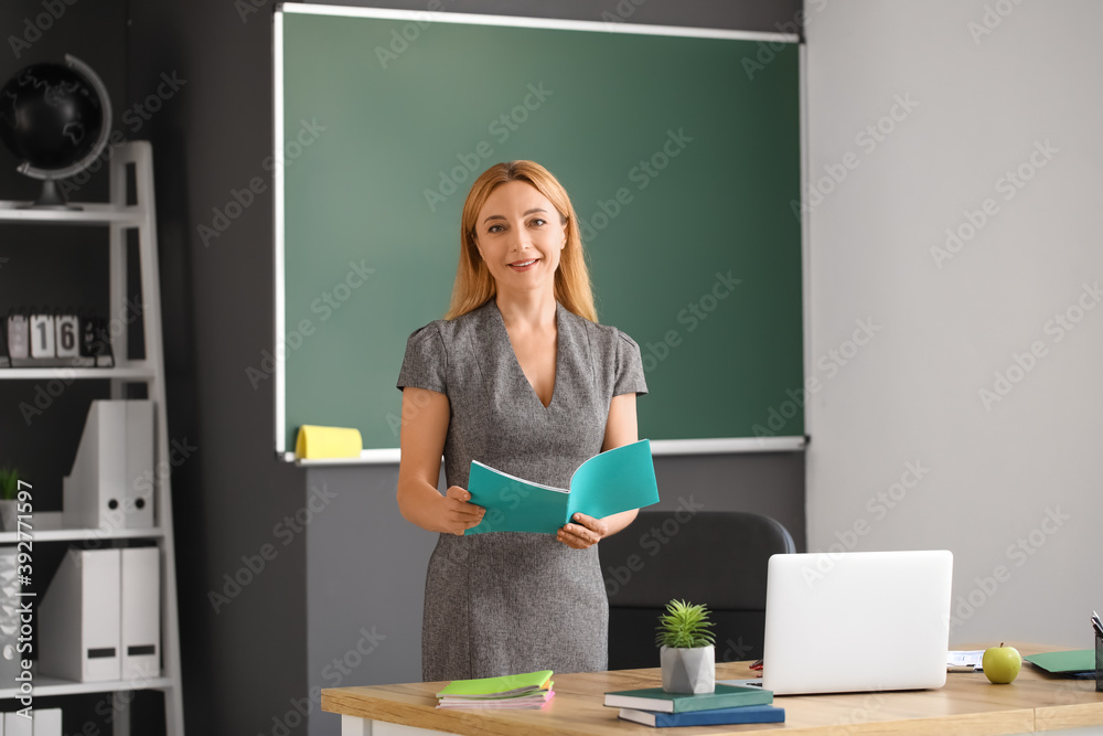 Mature female teacher conducting lesson in classroom